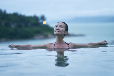 亚洲美女的肖像微笑和放松在泳池在黎明