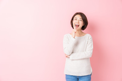 漂亮的亚洲女人用健康的牙齿拿着牙刷，口腔护理