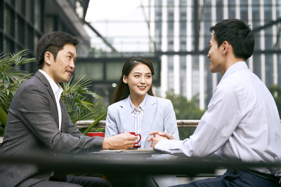 亚洲商务人士在户外咖啡店聚会