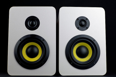 白色扬声器在黑色背景上。极简音频扬声器与黄色低音炮