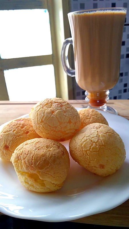 巴西传统的奶酪面包和热巧克力饮料在木制托盘。Pao de queijo。