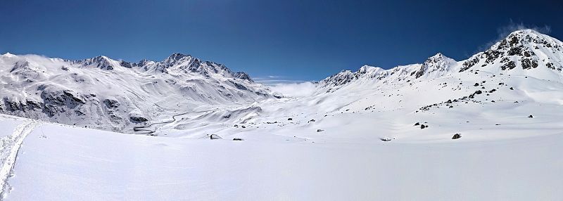 在美丽的雪山上滑雪登山。游览瑞士的弗拉帕斯山脉。全景照片