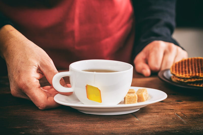 侍者端着一杯茶