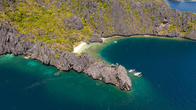 岩石海岸，白色沙滩。热带雨林岛屿