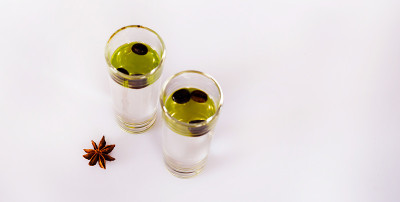芳香茴香酒精与咖啡豆装于玻璃杯中，饮具
