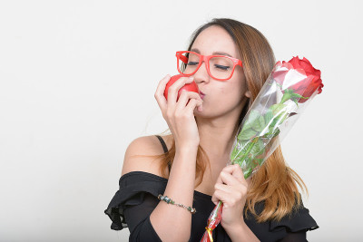 极客女人拿着一朵花和一个苹果