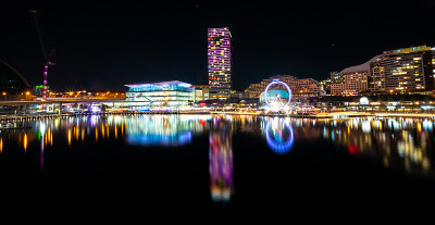 悉尼港和达令港城市天际线的全景夜景和澳大利亚Barangaroo明亮的霓虹灯反射的水