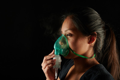 女人脸上带着喷雾器面罩