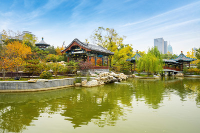 秋天，中国山西省太原市迎泽公园里有古建筑和拱桥