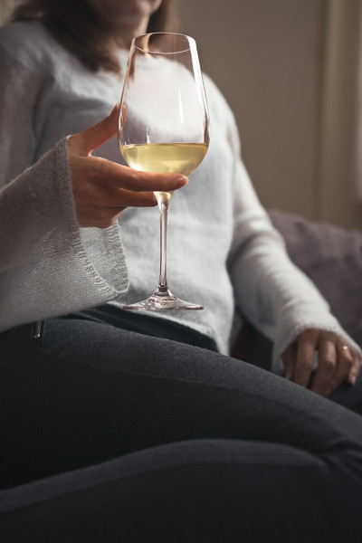 成年女性放松下来，喝了一杯葡萄酒