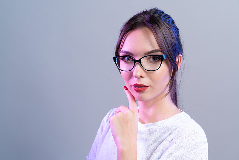 女商人用手托着下巴，充满自信和成功的情感。