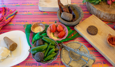餐桌上有新鲜的食材，如鳄梨，辣椒，西红柿。和molcajete