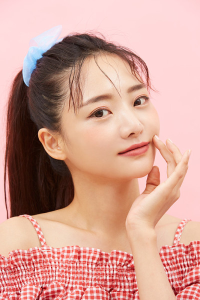 在粉红色的背景上的年轻亚洲女孩的随意美丽肖像