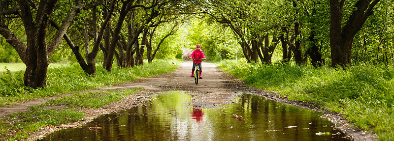 little girl riding bike in water puddle