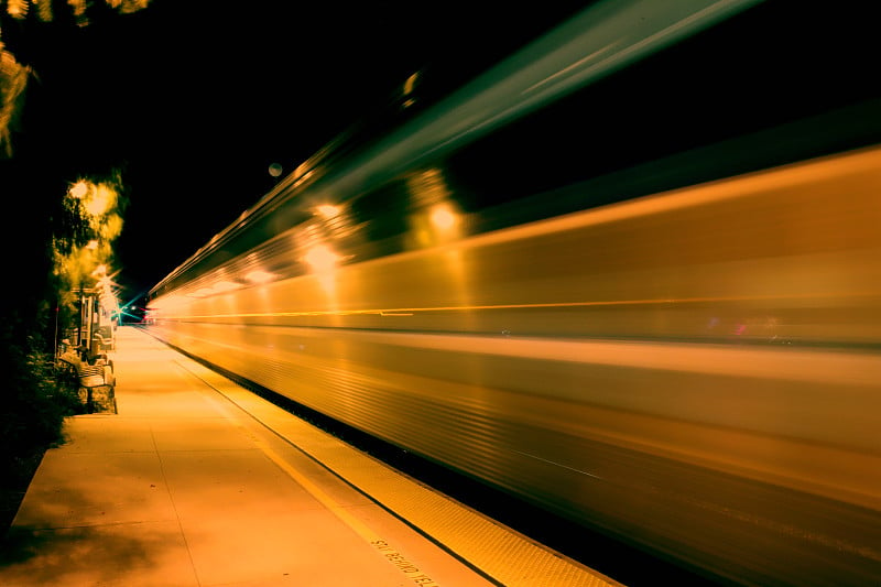 High-speed train passing Moorpark Station at night