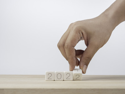 新年快乐，2022背景概念。近距离手翻转木制立方体块的变化数字从2021年到新的2022年在白色背景