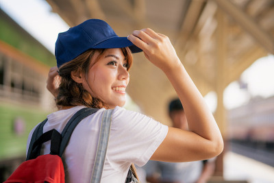 快乐的亚洲年轻女孩旅行背包冒险户外乘火车。