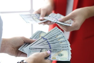 One hundred USA dollar bills are being counted in 