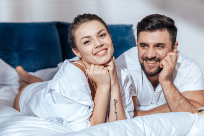 年轻幸福的夫妇在床上的肖像