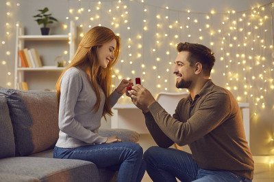 一个快乐的年轻人向他的女朋友求婚，并送给她一枚漂亮的订婚戒指