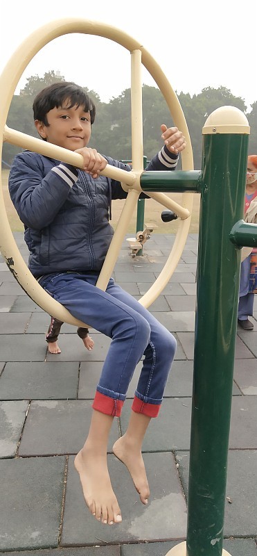 英俊的小男孩在操场上玩。
