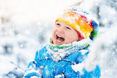 婴儿在冬天玩雪。白雪公园里的孩子。