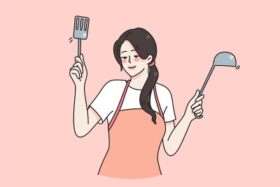 幸福的家庭主妇在围裙上拿着厨具烹饪食物