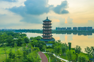 清晨的阳光照在公园湖边的古塔上