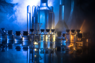 药学和化学主题。在研究实验室用溶液测试玻璃烧瓶。科学和医学背景。深色背景上的实验室试管