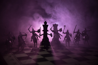 中世纪的战斗场景，骑兵和步兵在棋盘上。棋牌游戏的商业理念和竞争理念与战略理念棋牌人物在黑暗的背景下。
