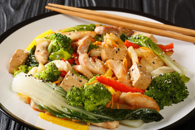 美味的爆炒蔬菜，鸡肉和豆腐在一个盘子的特写。水平