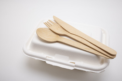 木勺和刀叉，甘蔗渣食品盒，白色背景的一次性餐具。环保的材料