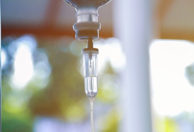 医院病房内生理盐水袋静脉滴注、医疗理念、治疗病人急诊和注射药物输液护理化疗理念。蓝色背景医院选择性聚