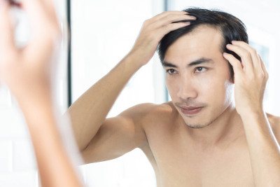 近距离看男人在镜子中反射严重的脱发问题为保健洗发水和美容产品的概念