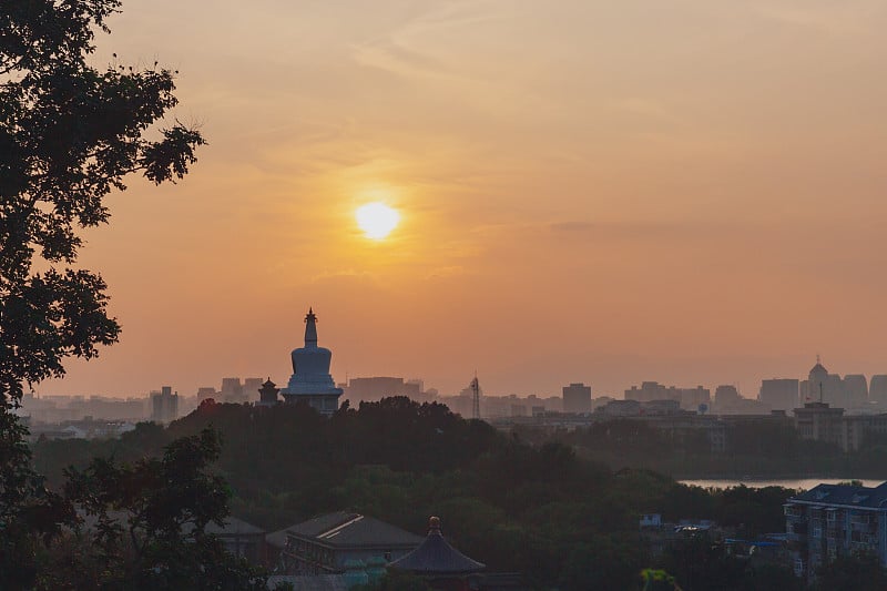 从北京景山公园看日落时北海公园的白塔