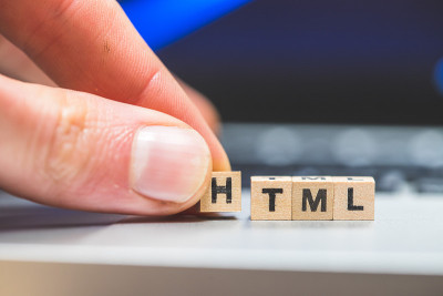 HTML网络语言:放置在笔记本电脑上的带有字母“HTML”的木制立方体，这是HTML的概念