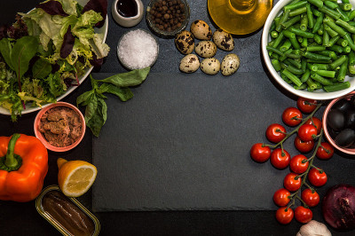 俯视图，平放。制作法式色拉的材料niçoise(尼斯)，在黑石切菜板周围。副本的空间。