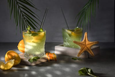 柠檬水或莫吉托鸡尾酒配柠檬橙和薄荷在灰色背景下清凉的饮料