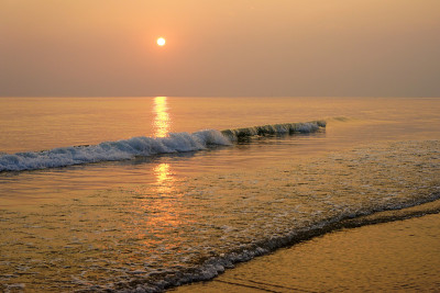 温暖的金色日出在汹涌的海浪上
