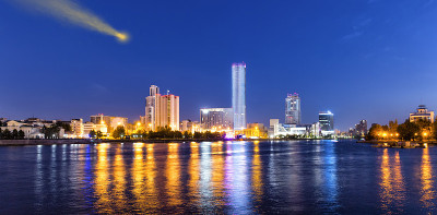 彗星在摩天大楼的夜空中。摩天大楼的夜景。河中的倒影