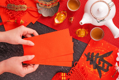 中国农历一月新年的设计理念——女人拿着，给红包(ang pow，红包)作为压岁钱，俯视图，平躺，头顶