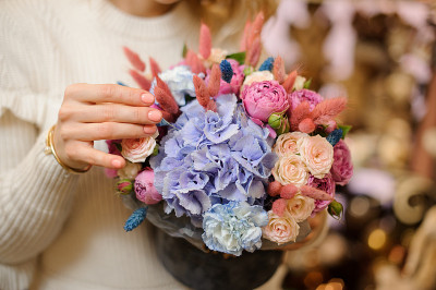特写美丽的花与绣球花，玫瑰和牡丹在女性手中。