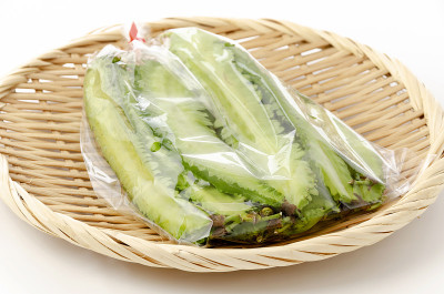 新鲜的飞豆装在塑料袋里，竹筛在白色的背景上