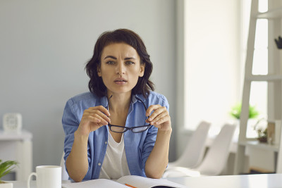 年轻细心的女人看着网络摄像头在网上会议