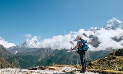 年轻的徒步背包客男子与徒步杆享受Ama Dablam 6814米的山峰在高海拔适应行走。珠峰大本营路