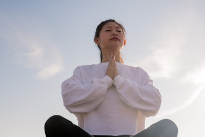 年轻的亚洲女人在早上坐着冥想