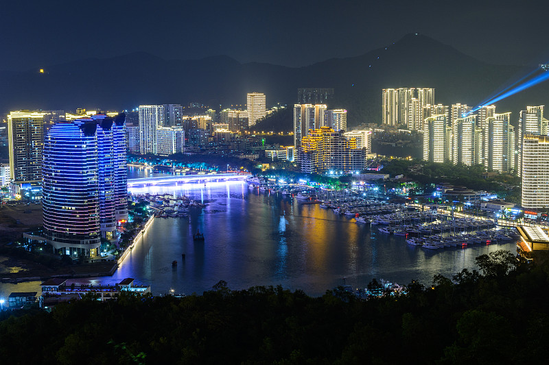 夜景三亚市与明亮的彩色照明建筑，结构，道路，人行道，杆子，桥梁。