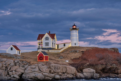 缅因州的诺布尔灯塔(Nubble Lighthouse)上乌云密布，夜幕降临