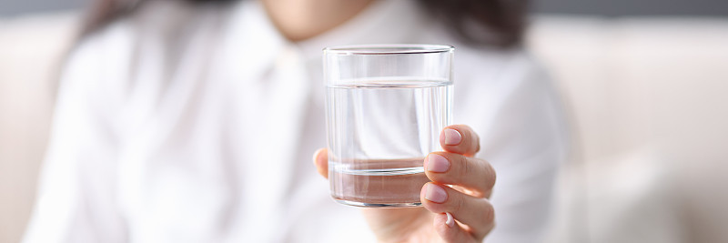 女人手里拿着一杯透明的水