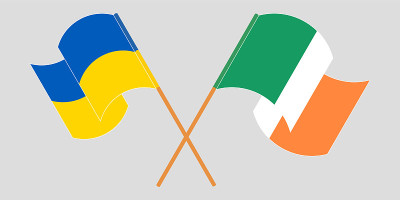Crossed and waving flags of the Ukraine and Irelan